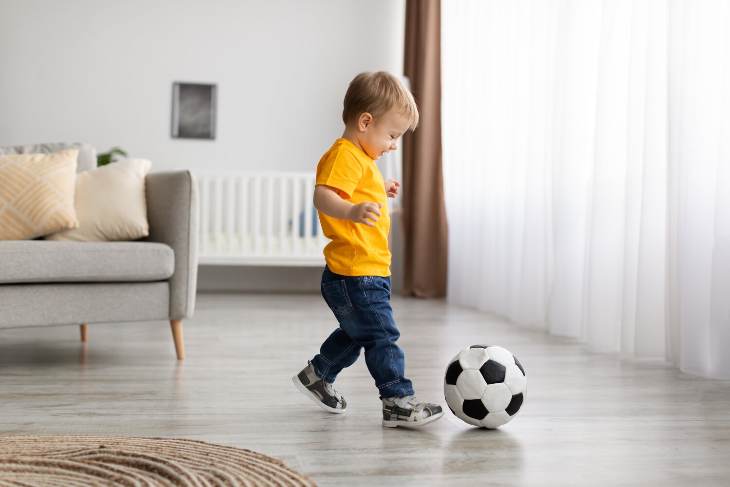 A toddler boy playing with ball