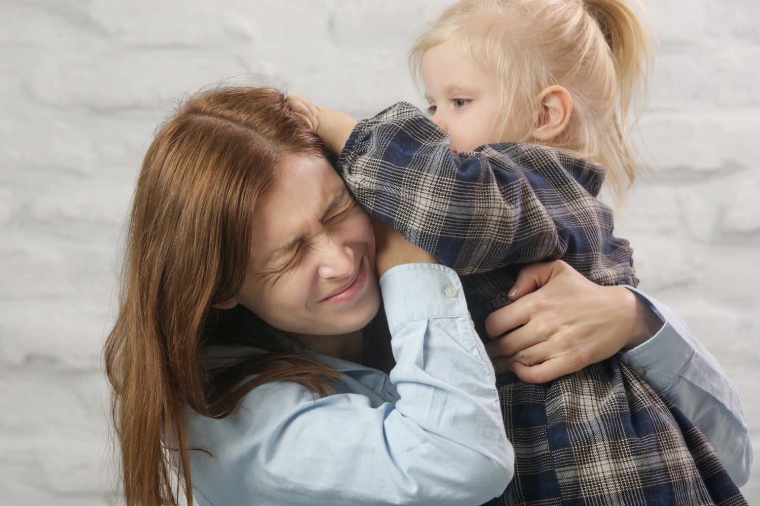 A toddler girl pulling her mother's hair