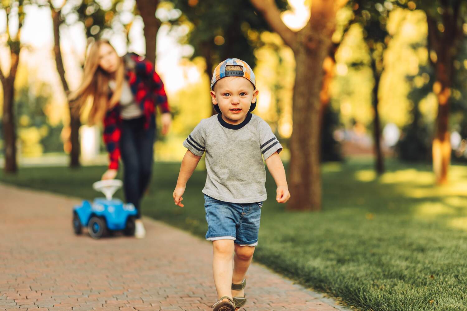 A toddler boy running away from his mother