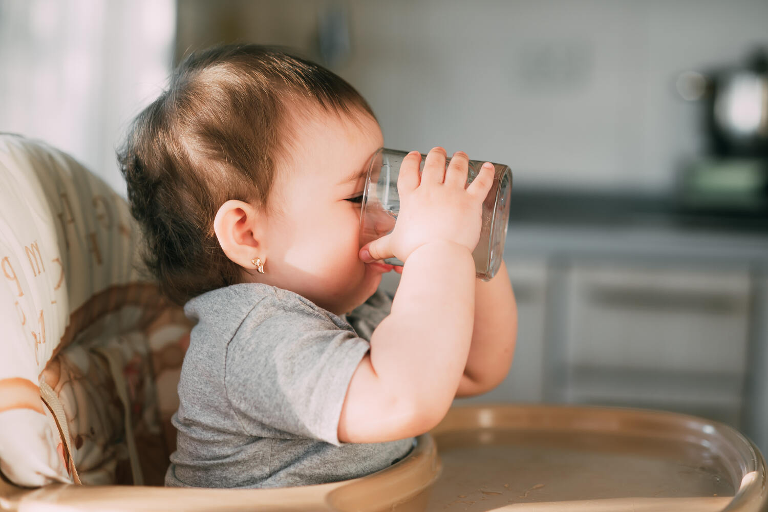 A toddler drinking from open cup