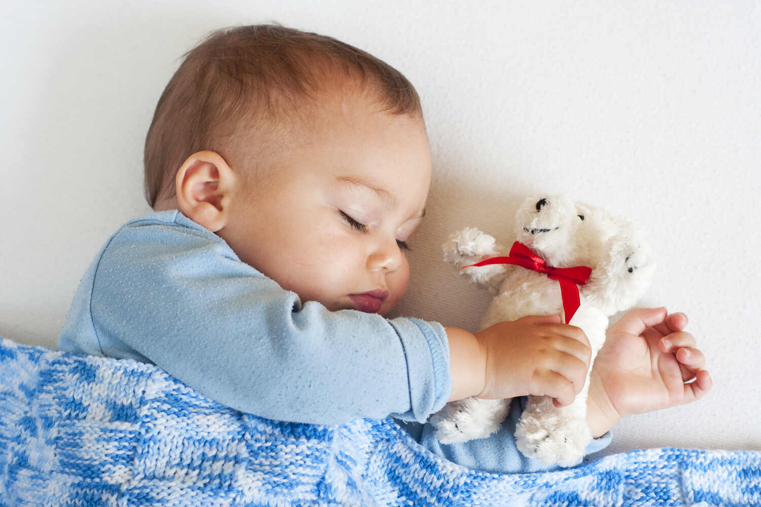 A toddler sleeping with his soft toy