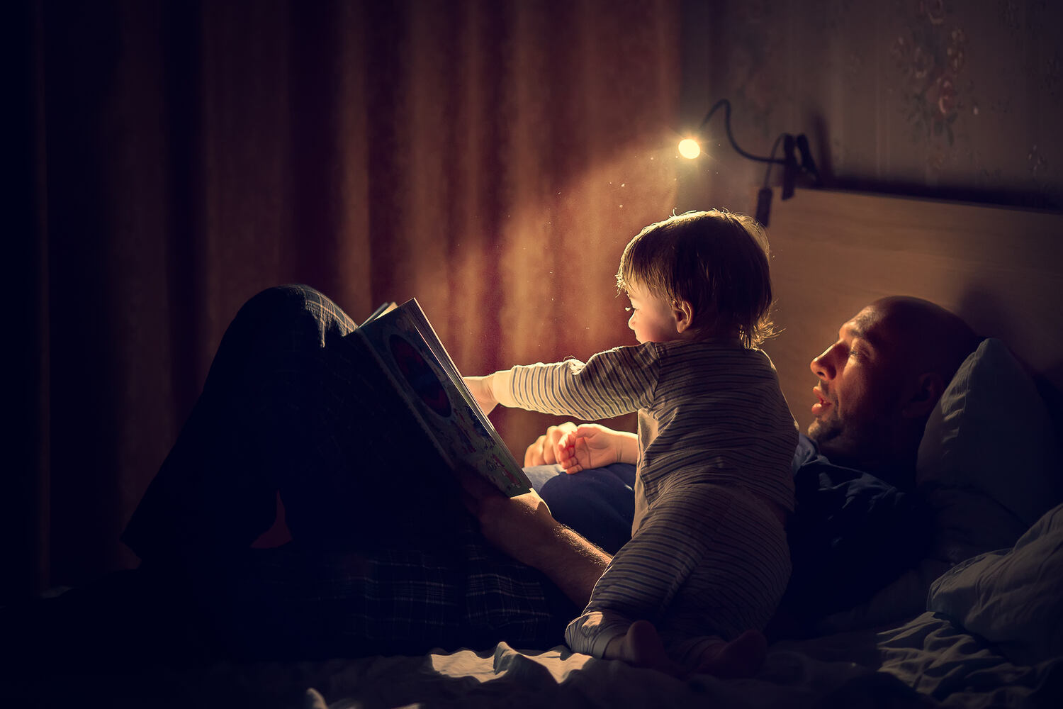 A father reading bed time stories to his toddler