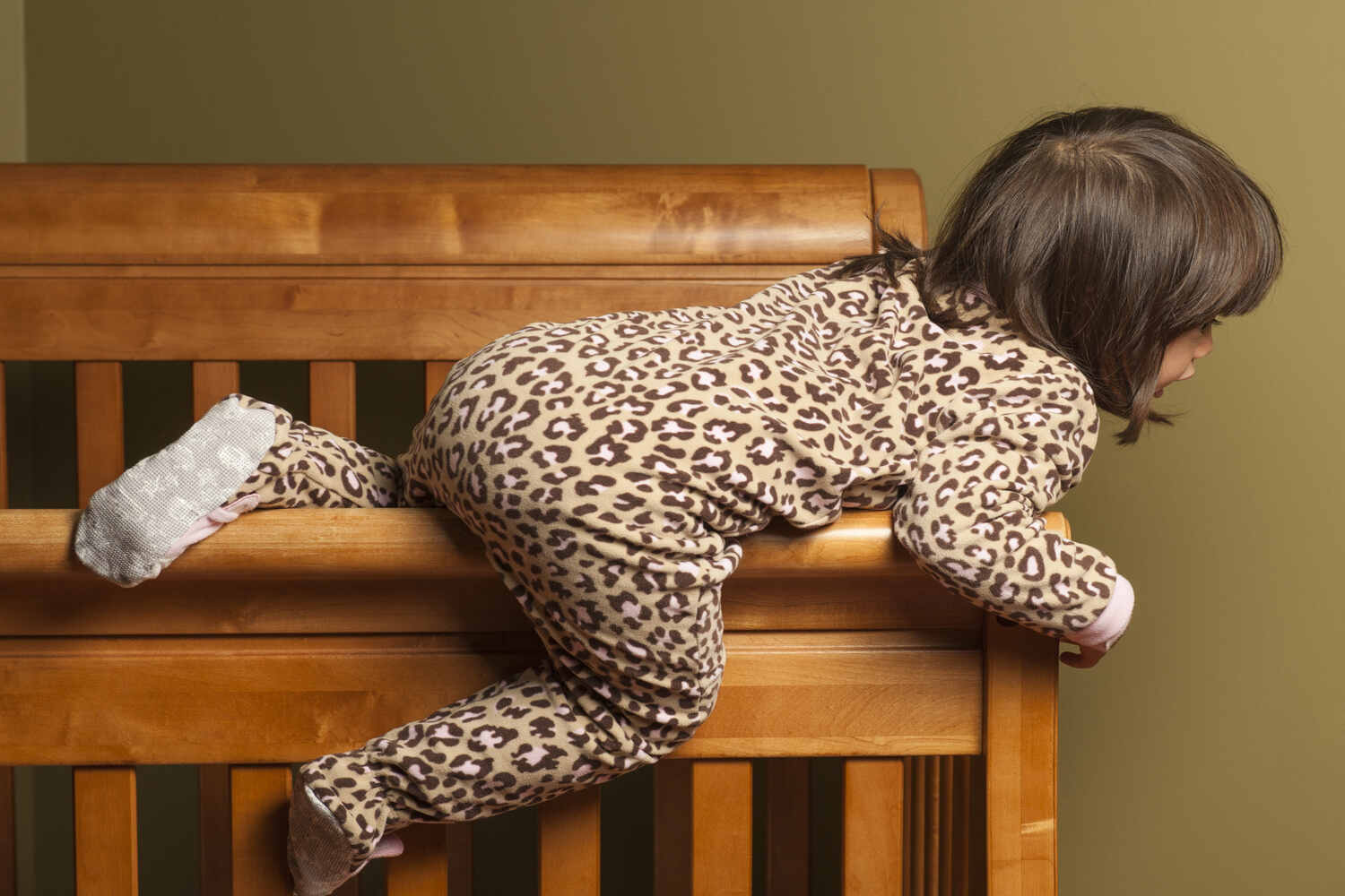 A toddler climbing out of crib
