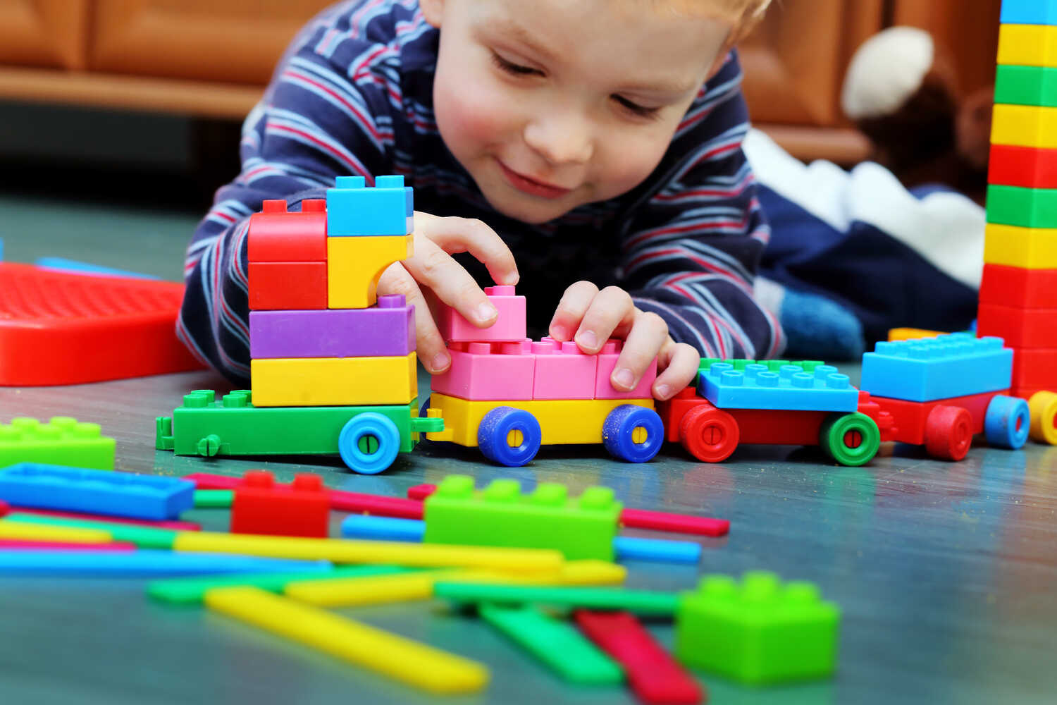 A toddler boy playing with building blocks