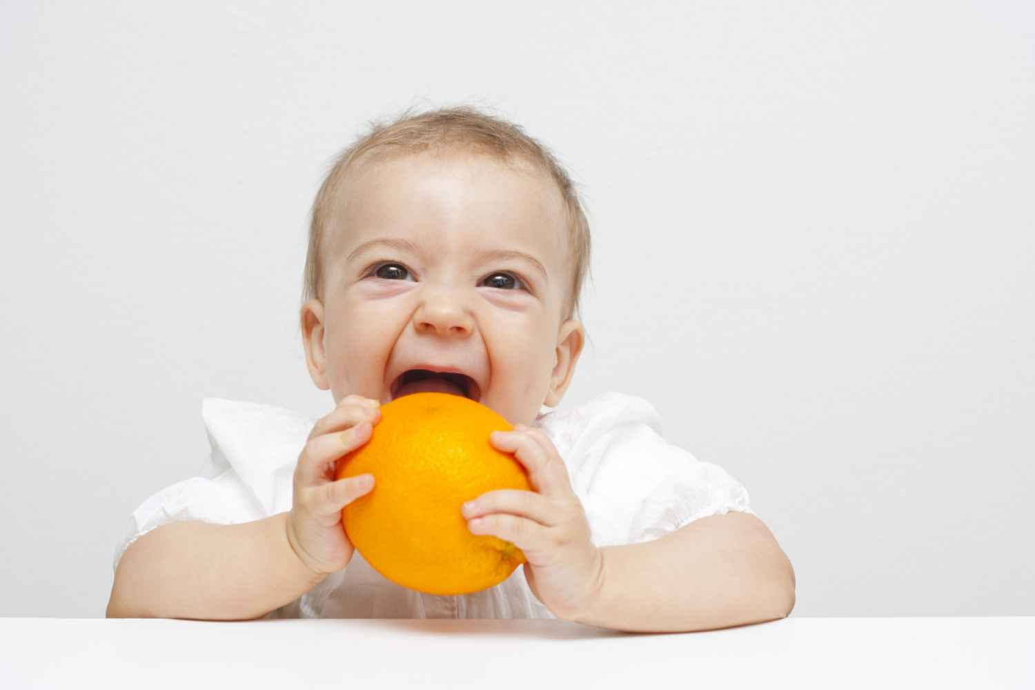 Baby eating orange