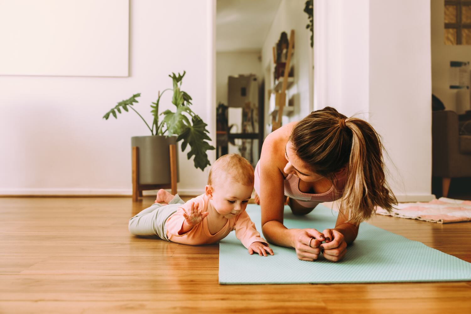 Mom doing planks with baby