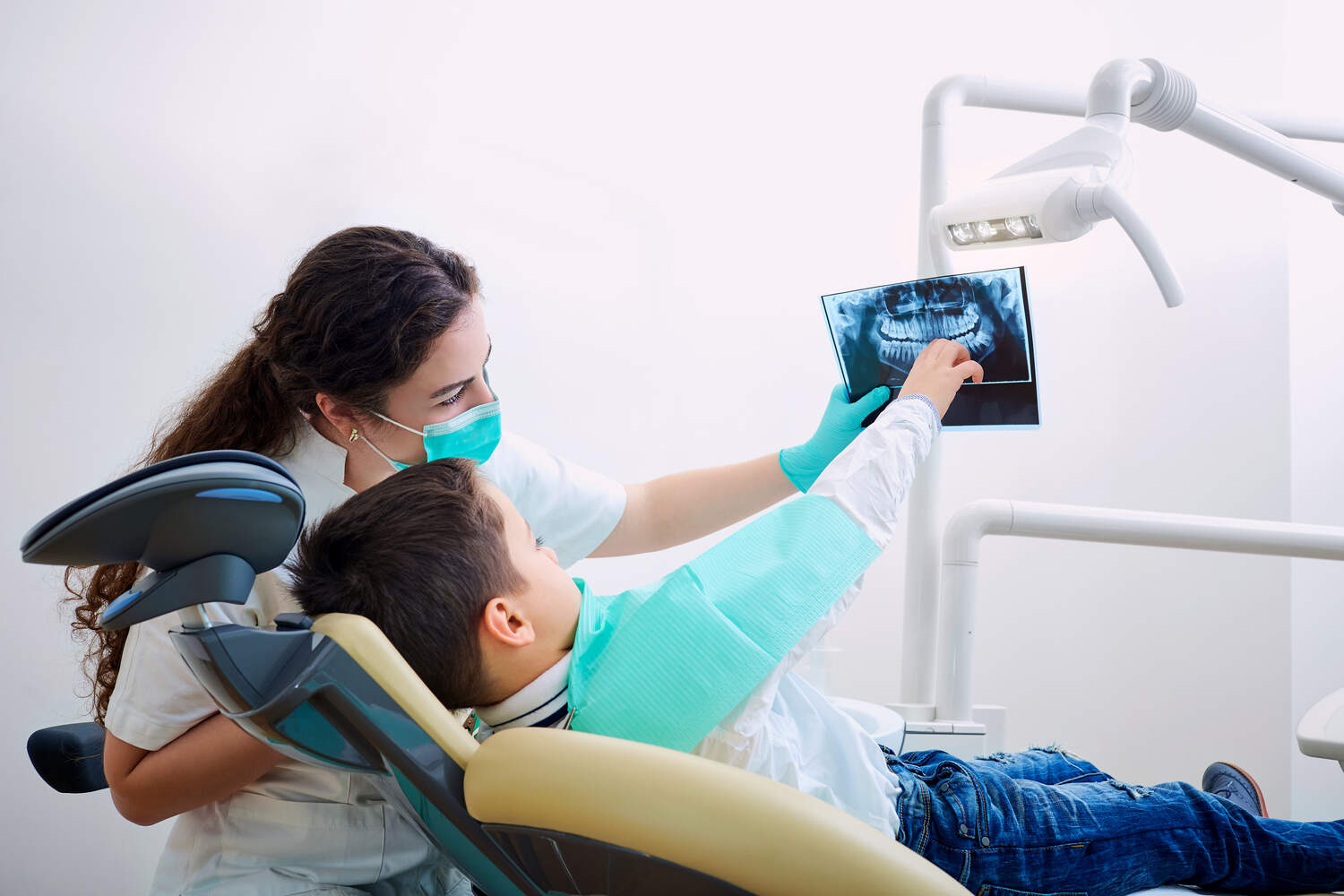 A dentist and a child looking at dental X-ray