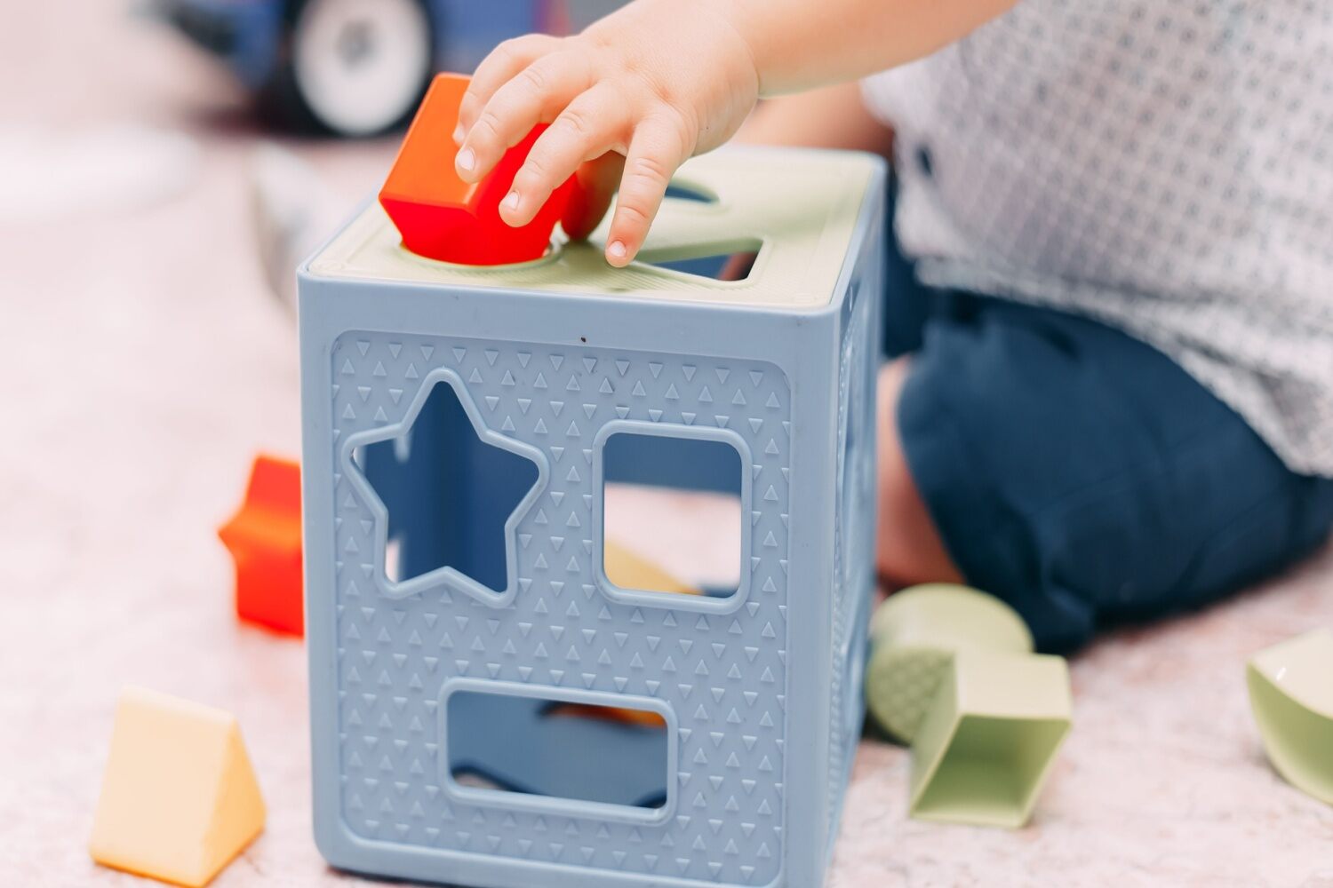Toddler playing with shape sorter toy