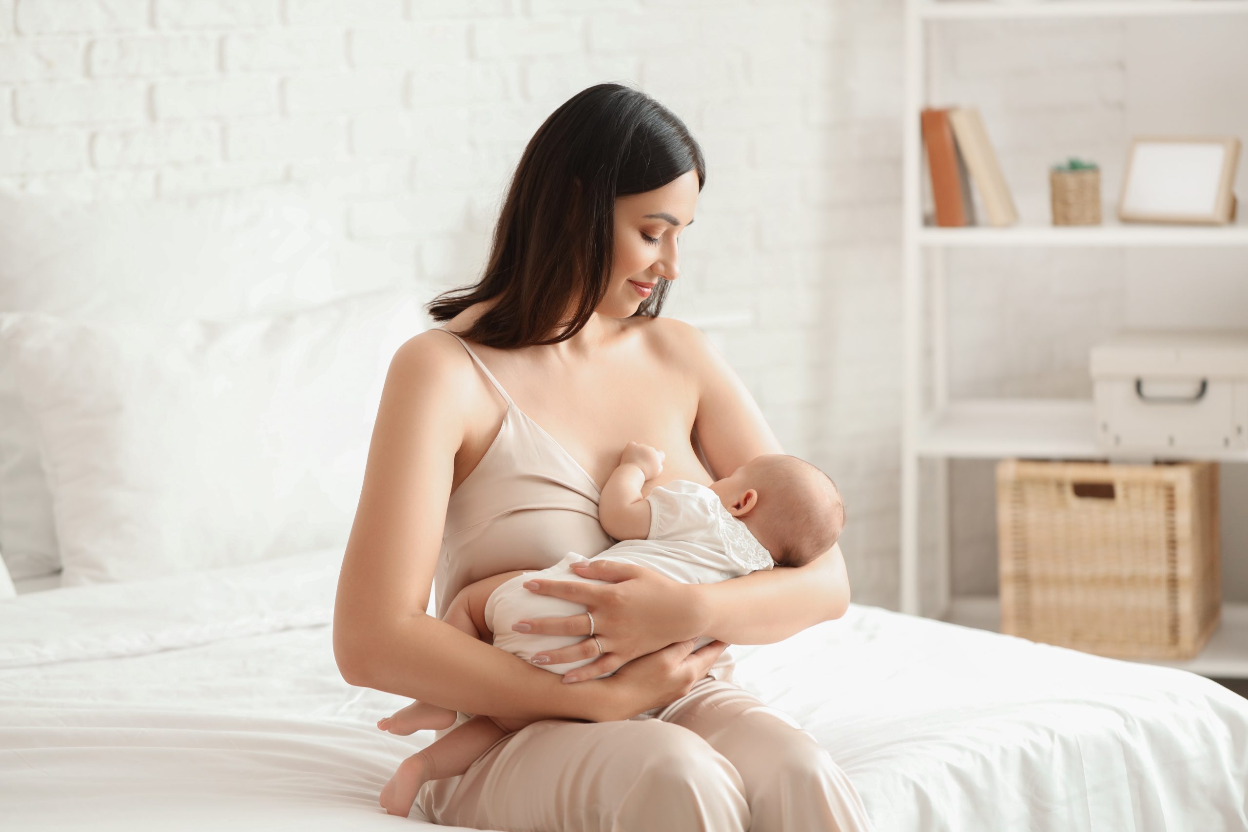 Young,Woman,Breastfeeding,Her,Baby,In,Bedroom