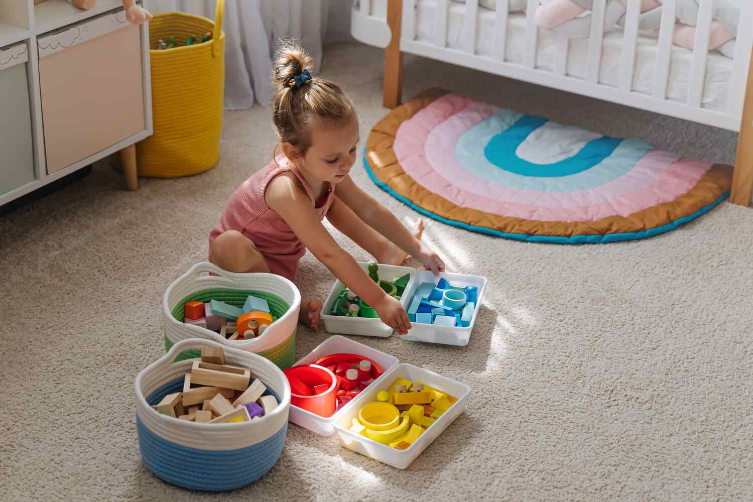 A toddler girl arranging her toys