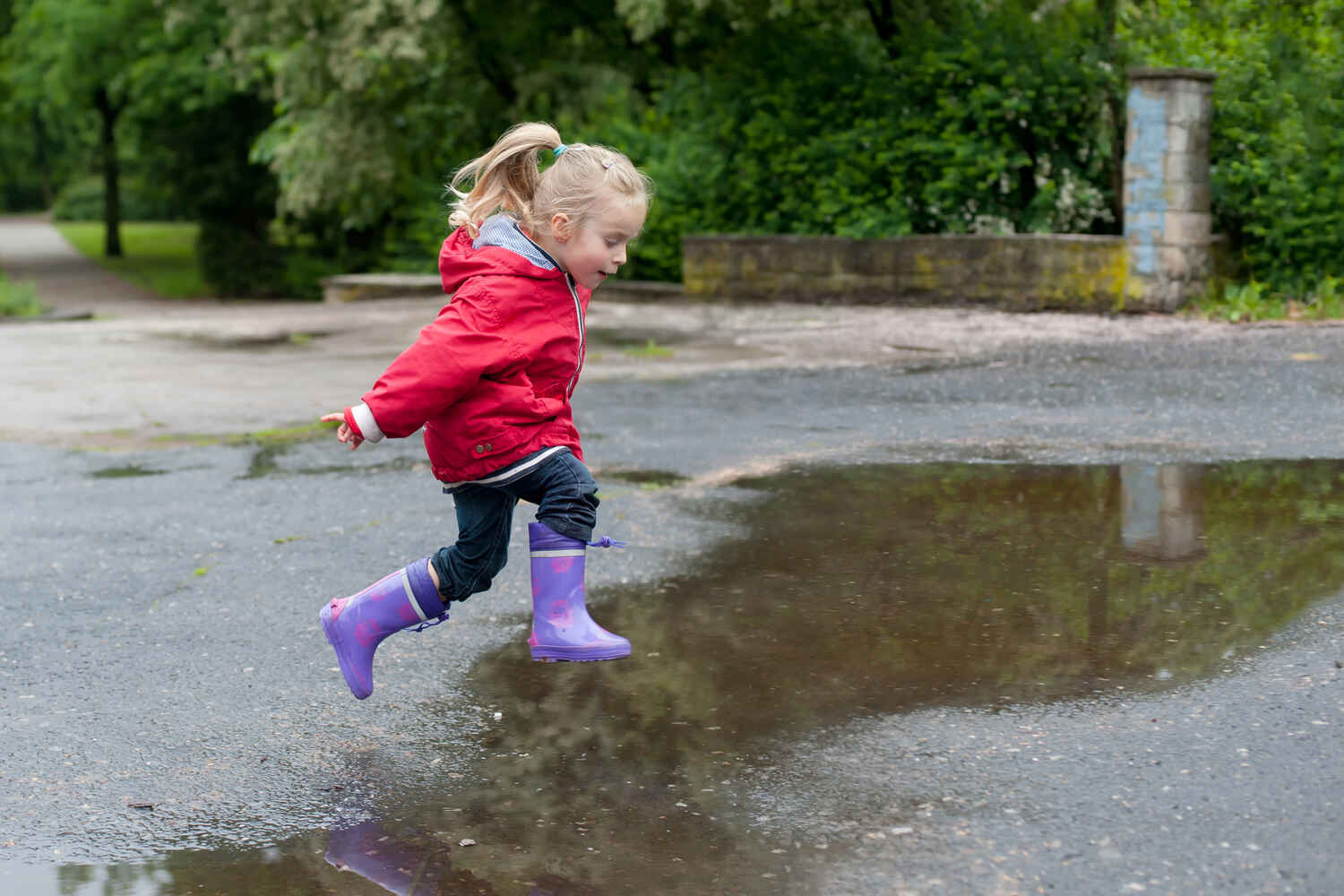 Little girl jumping in puddle